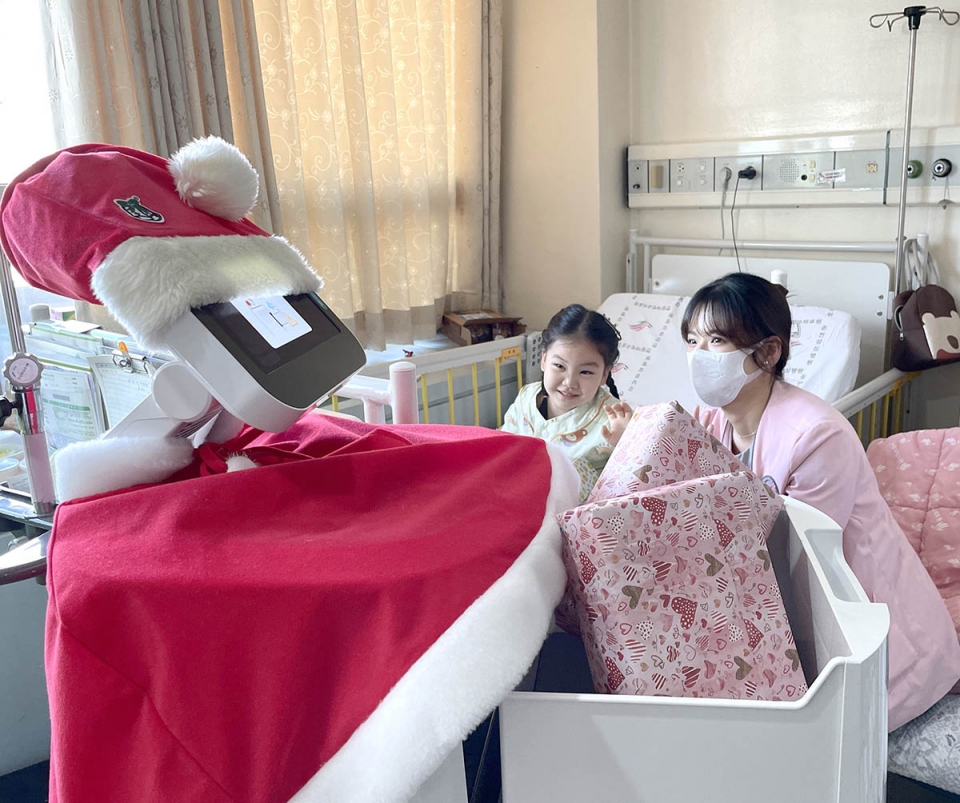 한림대성심병원에서 의료진을 보조하고 있는 로봇이 22일 일일 산타로 변신해 소아병동 환자들에게 크리스마스 선물을 나눠주고 있다. [사진=한림대의료원 제공]